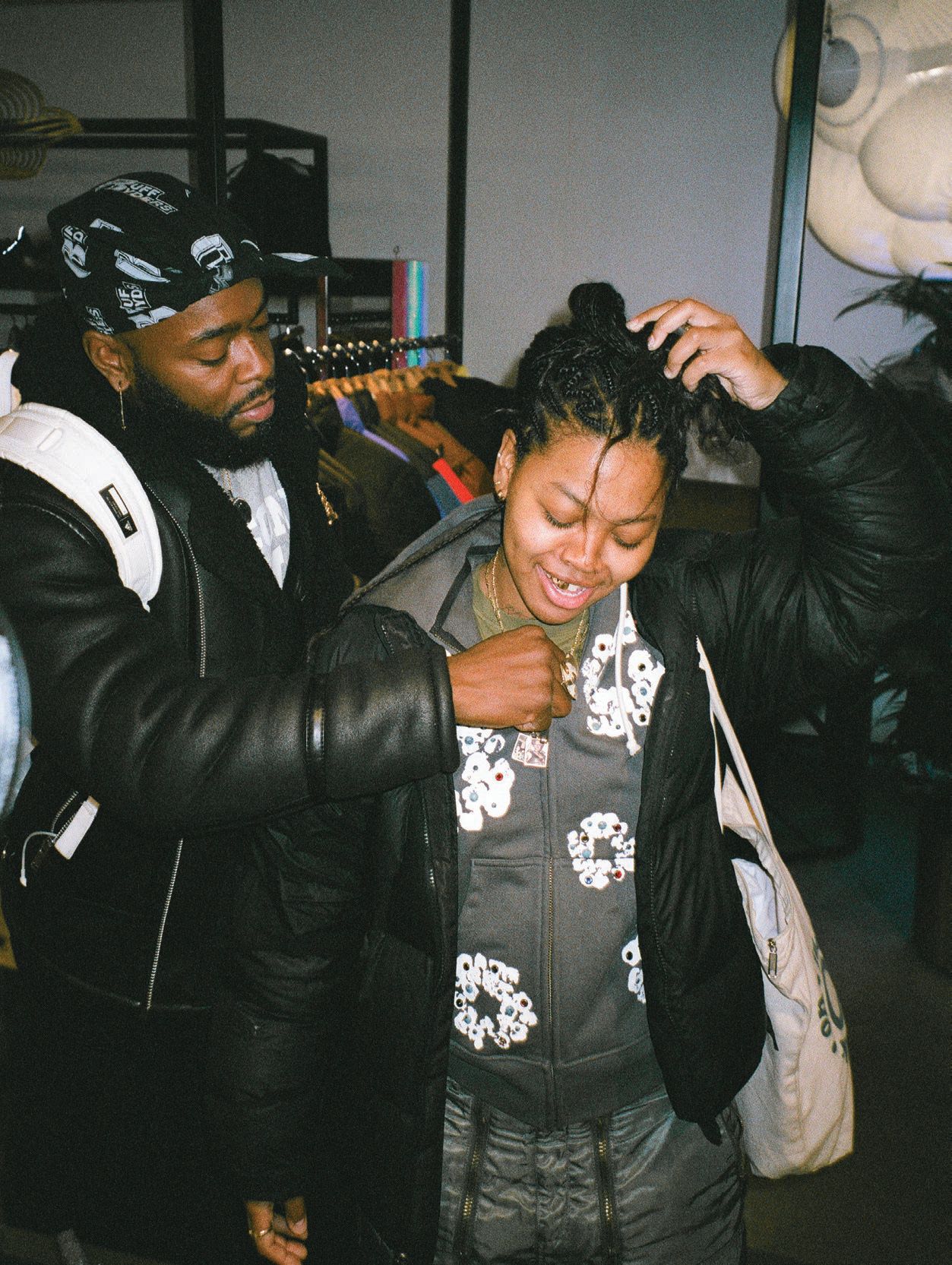 Nelson placing a custom nameplate necklace on artist Aya Brown at an installation at New York City’s Sneaker N Stuff shop in December 2022 PHOTO: BY @TELLI_NINJASONIK