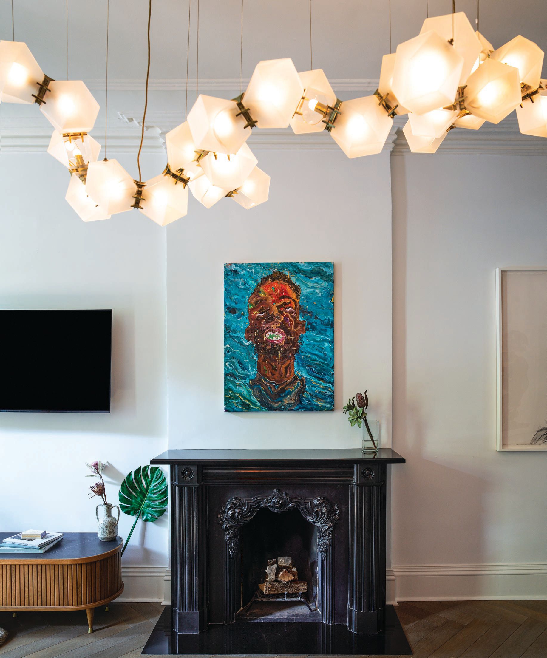 Ludovic Nkoth’s “Fallen Angel #1” (2020) hangs above the fireplace. Photographed by Frank Frances