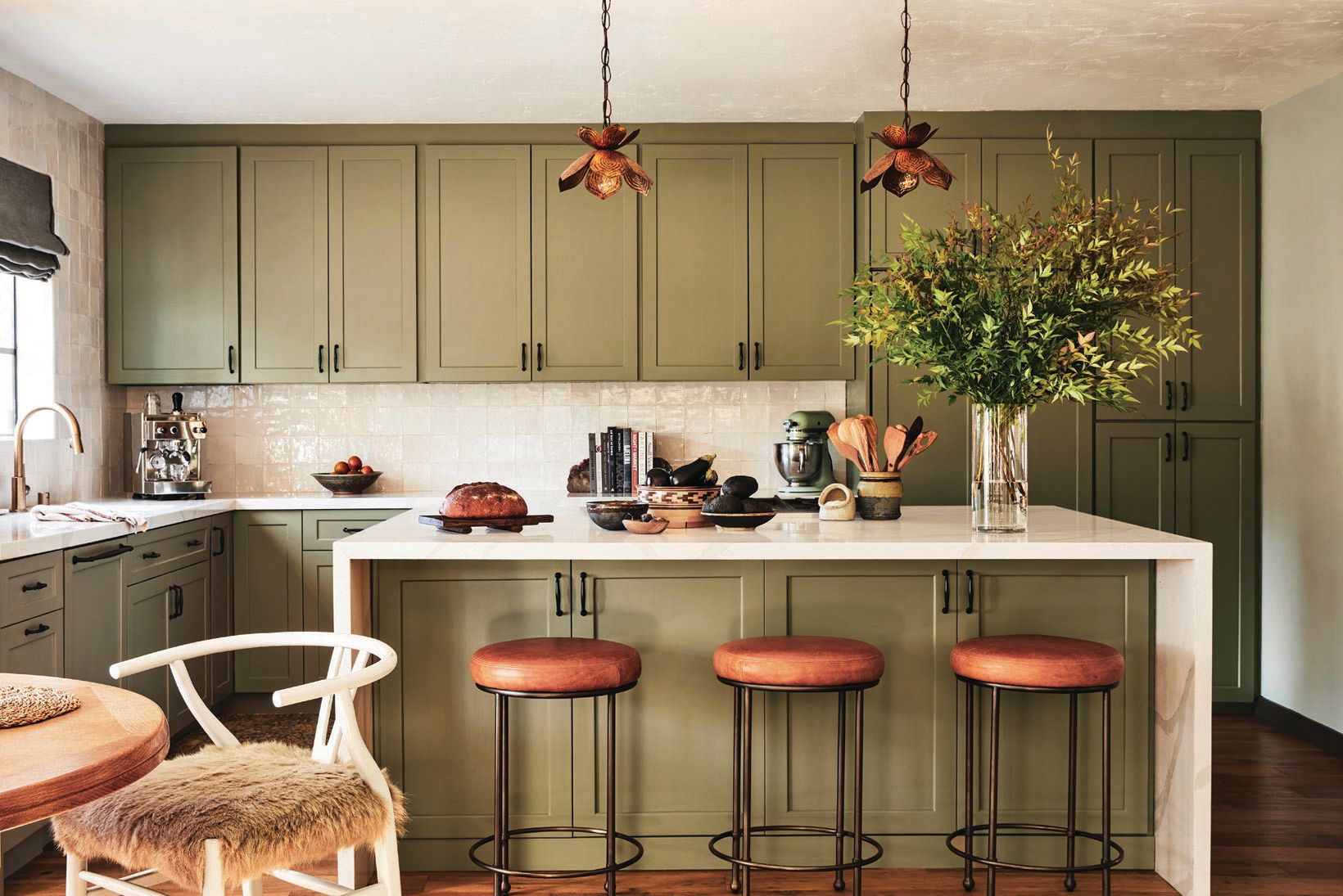 The kitchen’s Lawson-Fenning Orsini counter stools mingle with a vintage French breakfast table and cabinets painted in a custom shade by Portola Paints & Glazes. Photographed By Sam Frost