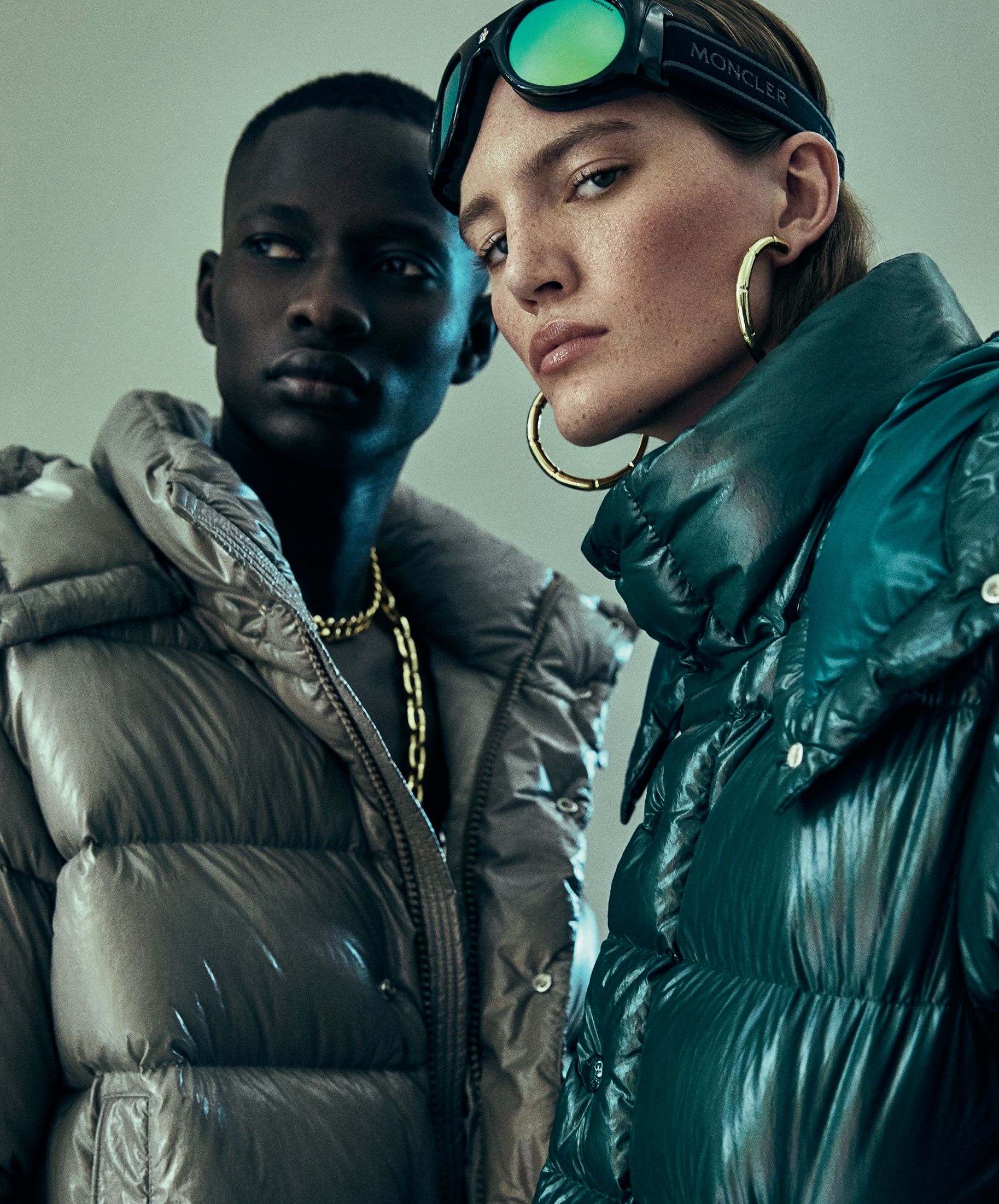 From left: Moncler Maya 70 down jacket in Basalt Gray and in Forest Green with Moncler Lunettes City ski goggles with elastic band, moncler.com. Photographed by Yossi Michaeli Styled by Faye Power Vande Vrede